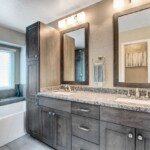 a bathroom remodel with a sink and mirrors modern look