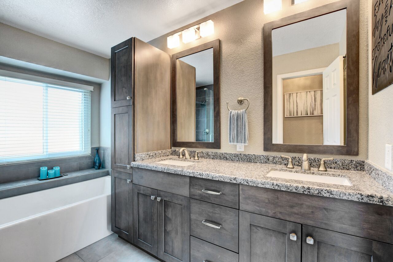 a bathroom remodel with a sink and mirrors modern look